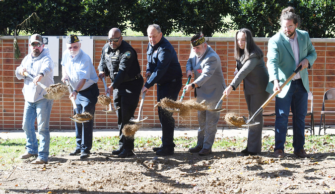From left: Doug Bayless of Vets Serving Vets, Middlesboro American Legion Post Commander Jim Davis, MPD Lt. Floyd Patterson, Middlesboro Fire Chief Robert England, VFW State Judge Advocate Jonathan Allen, City Council member Jade Robertson and Mayor Boon Bowling break ground for a new 9/11- War on Terror monument that is being added to the Veteran’s Park in front of Middlesboro City Hall. The ground-breaking was held on Veteran’s Day.
Father Isaac McKenzie from St. Mary’s Epsicopal Church gave an invocation, the MHS JROTC Color Guard presented the colors and the MHS band played the National Anthem.
MPD Officer Bucky Harris served as the host for the event.